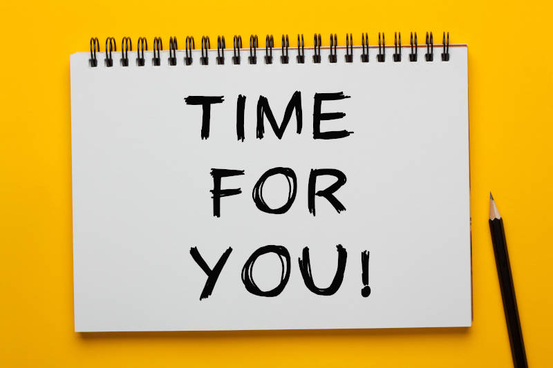 The phrase Time For You written on notepad with pencil on yellow background.